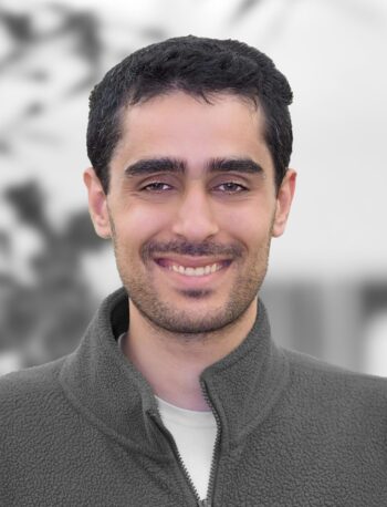 Portrait of Arik Singh, a smiling man with dark hair against a blurred background.