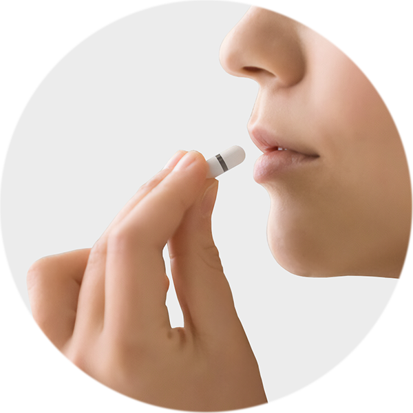 Person holding a swallowable IVD diagnostic capsule near their lips, about to take it.